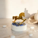 marturie botez calut auriu pe piatra decorativa alba, cu figurina din plexiglas auriu oglinda si cristale albastre