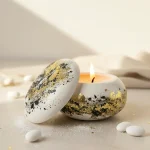 marturii nunta lumanare macaron ceramic alb cu foita de aur si detalii negre, asezata langa bomboane