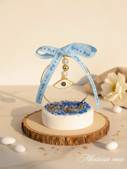 marturie simbol ochi protectie pe baza rotunda alba cu pietricele decorative albastre si auriu si fundita bleu