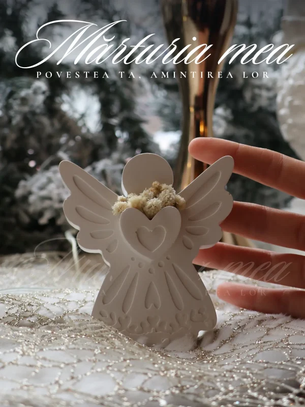 Mana unei persoane atingand delicat o marturie deosebita tip inger ceramic alb, evidentiind dimensiunea de 9cm si textura fina pe fundal festiv.