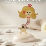 Marturie botez fetita sirena aurie cu coroana roz asezata pe o baza alba eleganta pentru invitati.