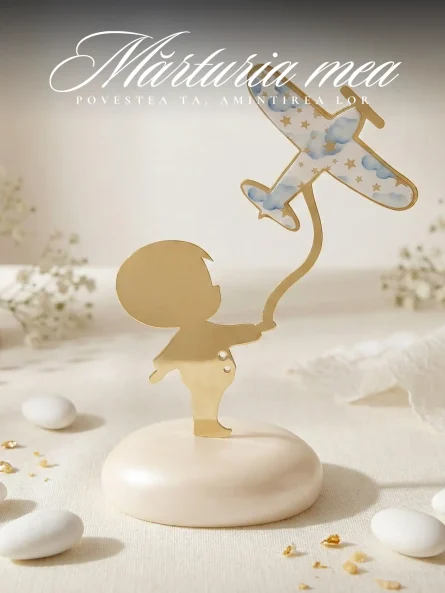 Marturii botez baiat avion sub forma unei figurine aurii cu baietel si avion decorat cu nori pe suport tip pietricica.